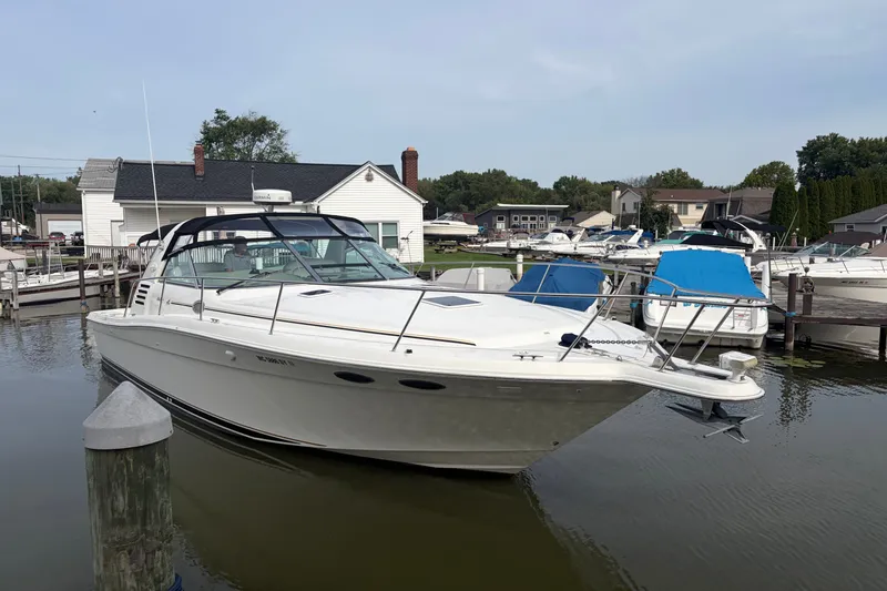 Slide: The Image of 1999 Sea Ray 370 Express Cruiser docked at a marina, surrounded by other boats. - 5