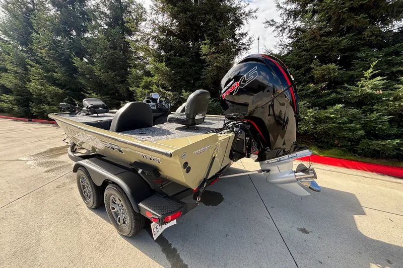 Slide: The Image of 2026 Tracker Pro Team 195 boat on trailer, parked outdoors near trees. - 13