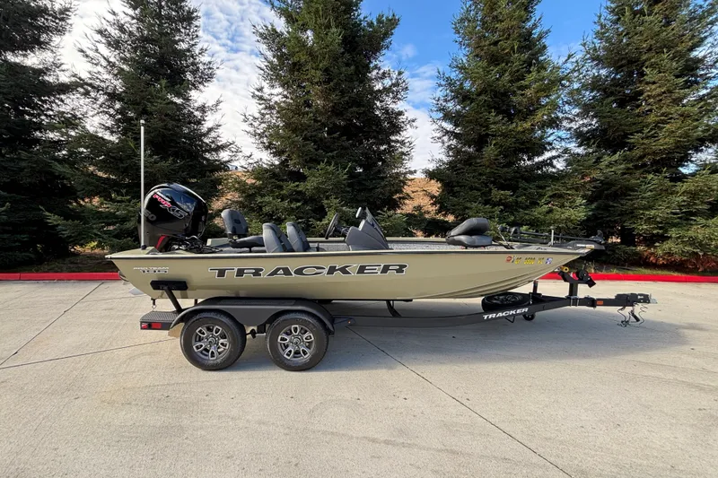 The Image of 2026 Tracker Pro Team 195 boat on trailer, parked outdoors with trees in background. - 0