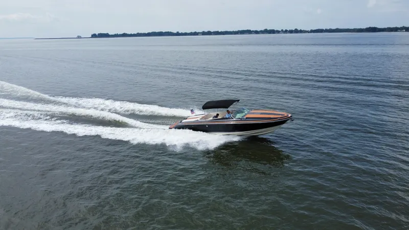 Slide: The Image of A 2020 Chris-Craft Corsair 34 speeds across the water, featuring a black canopy. - 5