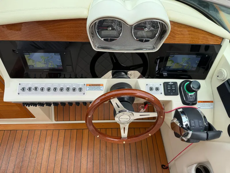 Slide: The Image of The image shows the cockpit of a 2020 Chris-Craft Corsair 34. It features a sleek wooden steering wheel, modern instruments, and a stylish dashboard. - 31