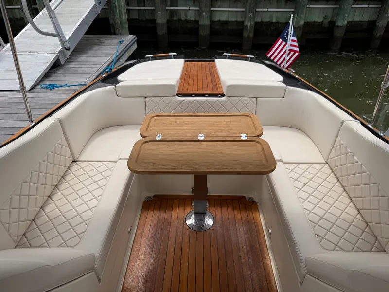 Slide: The Image of The image shows the cockpit of a 2020 Chris-Craft Corsair 34 with elegant leather seating and a wooden table. - 32