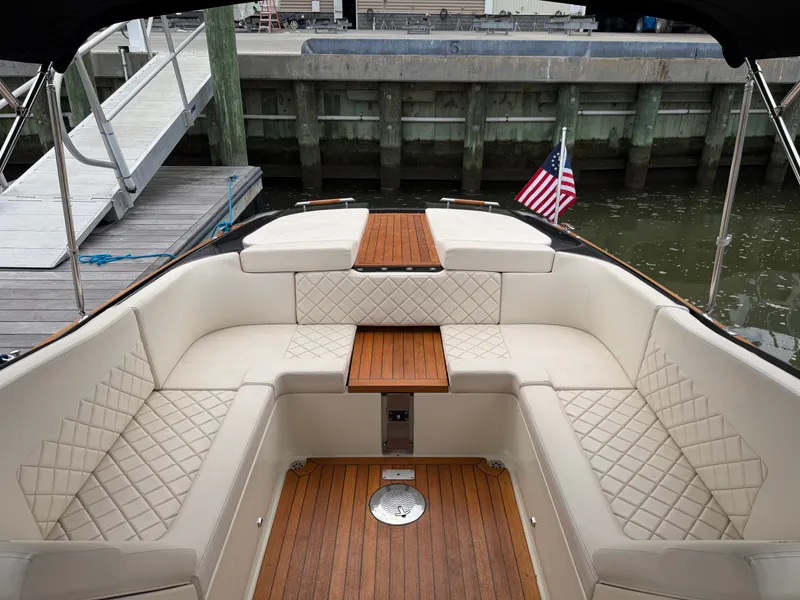 Slide: The Image of 2020 Chris-Craft Corsair 34 with elegant cushioned seating and wooden flooring, docked at a marina. - 35