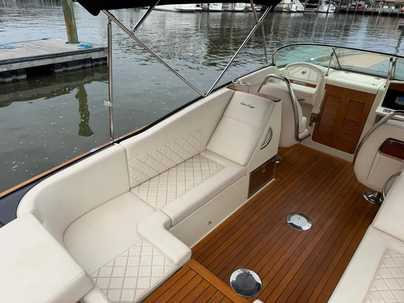 Slide: The Image of Chris-Craft Corsair 34, 2020 model, featuring elegant white seating and wood flooring by the water. - 25