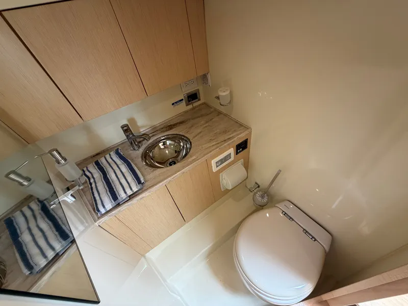 Slide: The Image of Interior view of a sleek bathroom with a sink, toilet, and wood paneling. - 47