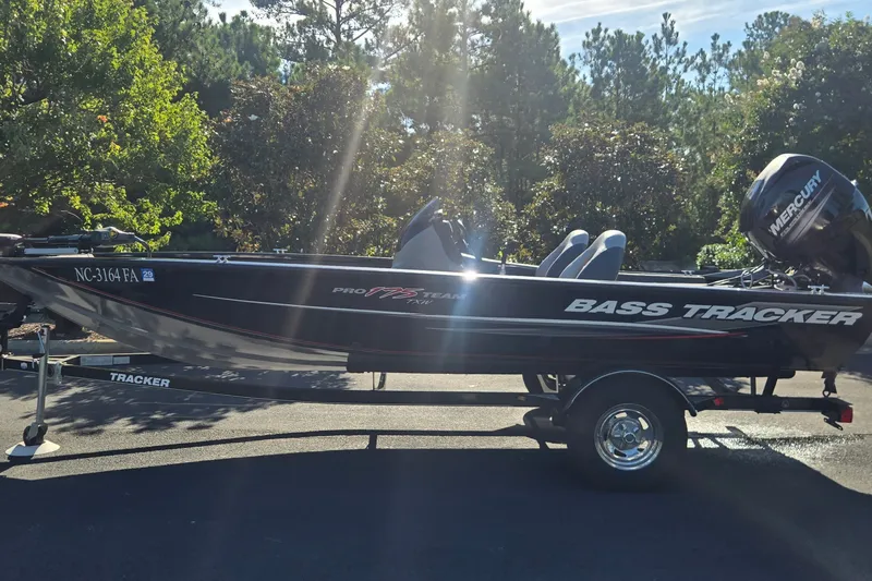 The Image of 2015 Tracker Pro Team 175 TXW bass boat on trailer, parked outdoors. - 0