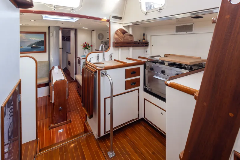 Slide: The Image of Interior of a 1970 Sparkman & Stephens 57 yacht with wooden flooring and compact kitchen. - 7