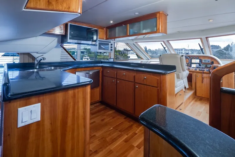 Slide: The Image of Luxurious 2004 Navigator Pilothouse yacht interior with sleek wood cabinetry and modern amenities. - 14