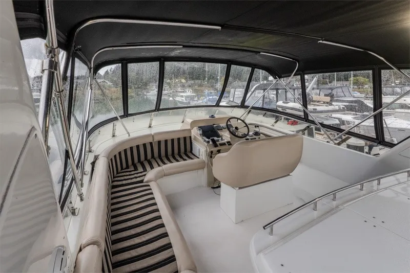 Slide: The Image of 2004 Navigator Pilothouse interior with helm, seating, and marina view. - 36