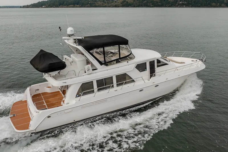 Slide: The Image of 2004 Navigator Pilothouse yacht cruising on open water, showcasing sleek design and spacious deck. - 2
