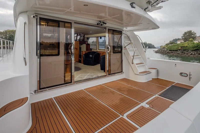Slide: The Image of 2004 Navigator Pilothouse yacht deck with sliding glass doors and wooden flooring. - 6