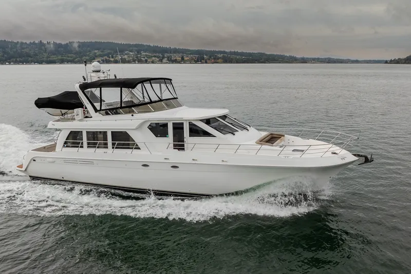 The Image of 2004 Navigator Pilothouse yacht cruising on a calm lake under cloudy skies. - 0