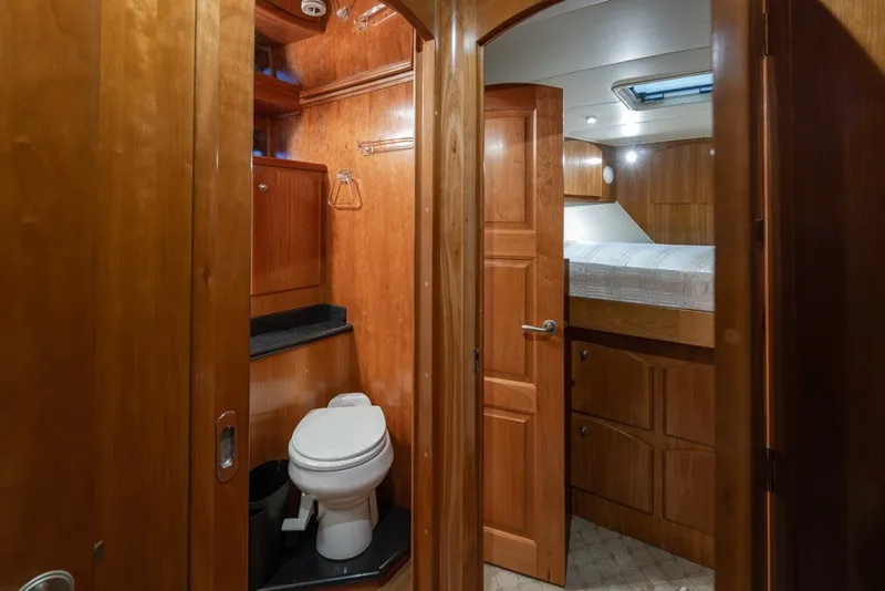 Slide: The Image of 2004 Navigator Pilothouse interior with wooden cabinetry, toilet, and cozy sleeping area. - 30