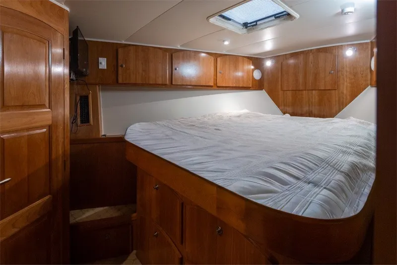 Slide: The Image of Luxurious 2004 Navigator Pilothouse cabin with wood paneling and cozy bedding. - 28