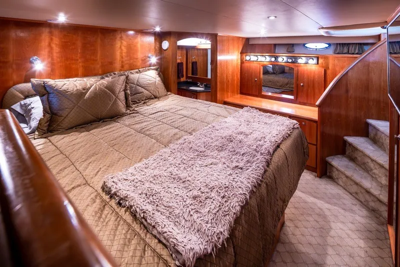 Slide: The Image of Luxurious 2004 Navigator Pilothouse bedroom with plush bedding and elegant wood finishes. - 20
