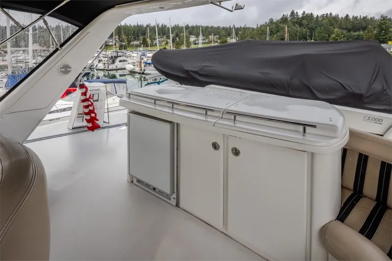 Slide: The Image of 2004 Navigator Pilothouse yacht interior with seating and covered equipment, docked at marina. - 40