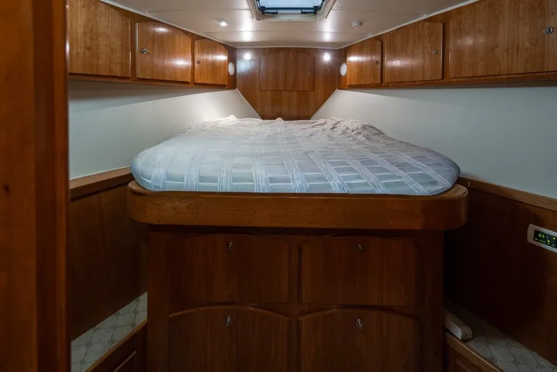 Slide: The Image of 2004 Navigator Pilothouse cabin interior with wooden cabinetry and a cozy bed. - 27