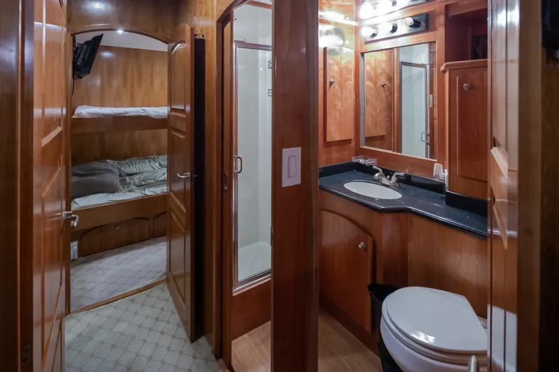 Slide: The Image of Luxurious 2004 Navigator Pilothouse yacht interior with wood finish, bathroom, and cozy bunk beds. - 25