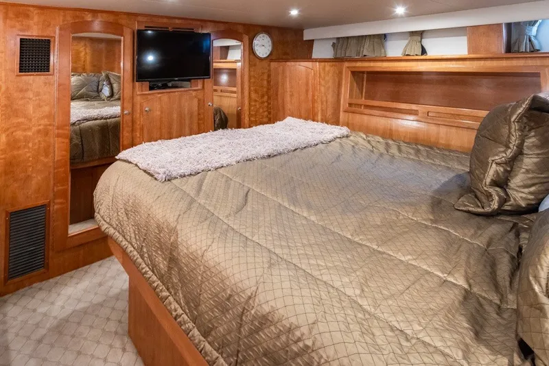 Slide: The Image of Luxurious 2004 Navigator Pilothouse yacht bedroom with wood paneling and plush bedding. - 22