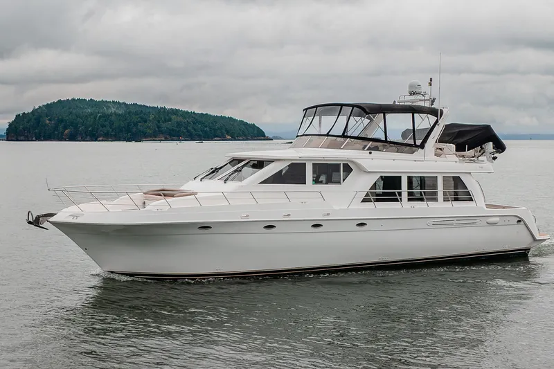 Slide: The Image of 2004 Navigator Pilothouse yacht cruising on calm waters near a forested island. - 46