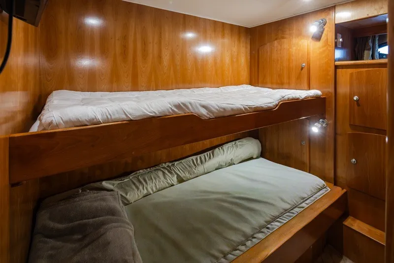 Slide: The Image of 2004 Navigator Pilothouse interior with wooden bunk beds and cozy lighting. - 29