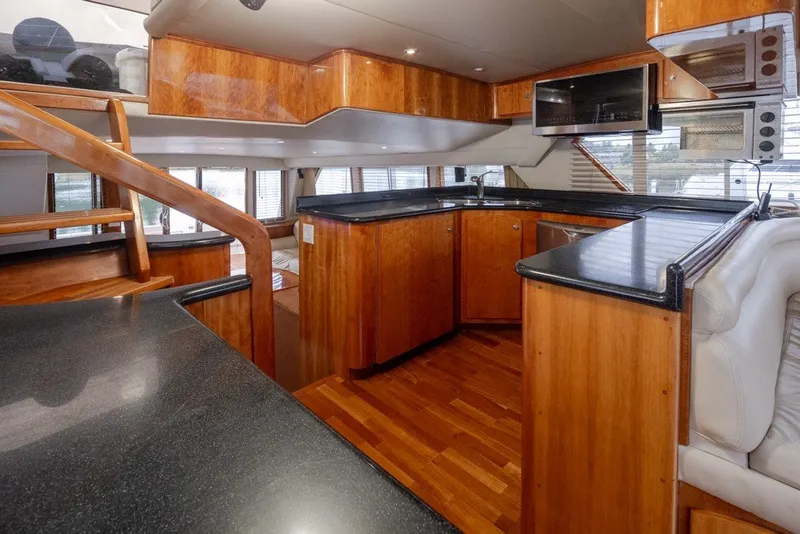 Slide: The Image of Luxurious 2004 Navigator Pilothouse yacht interior with sleek wood finishes and modern kitchen amenities. - 15