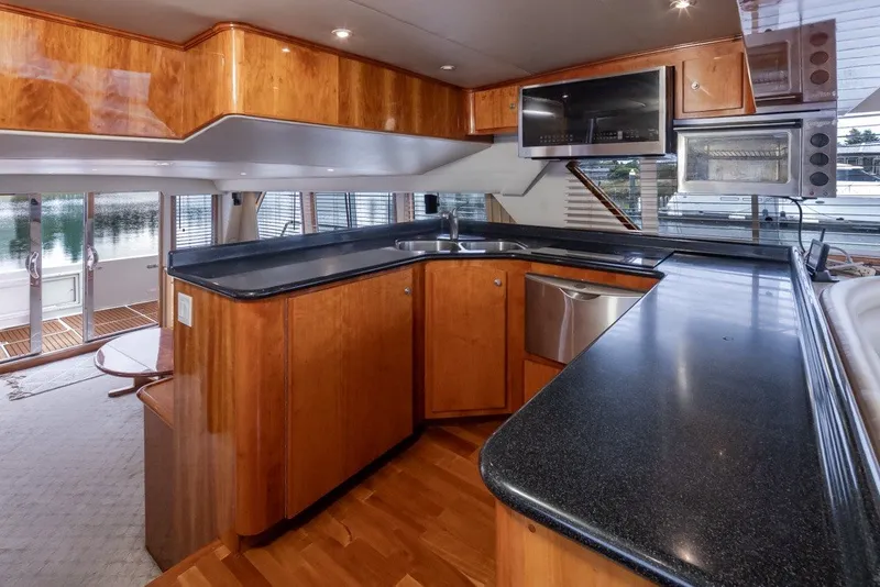 Slide: The Image of Luxurious 2004 Navigator Pilothouse yacht interior with modern kitchen and sleek wood finishes. - 16