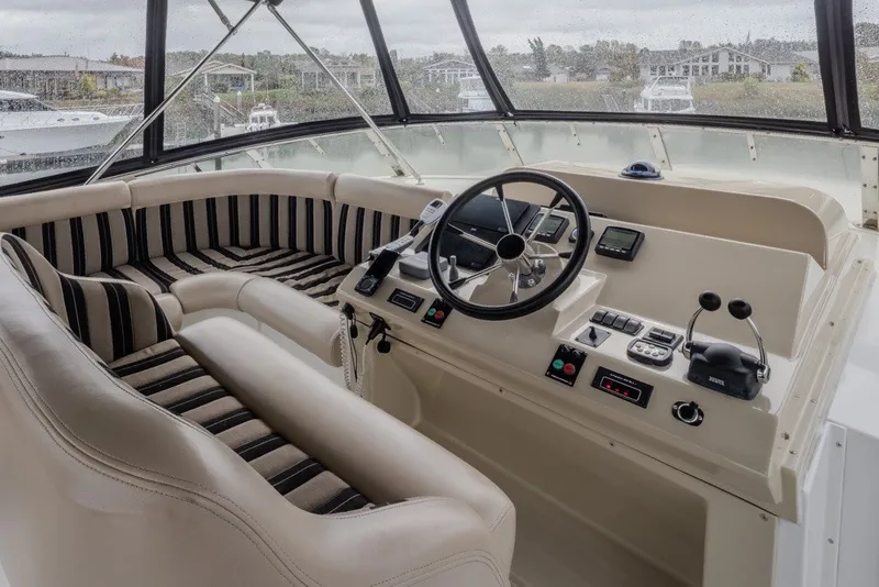 Slide: The Image of 2004 Navigator Pilothouse helm with striped seating and navigation controls. - 37