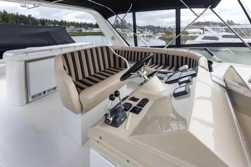 Slide: The Image of 2004 Navigator Pilothouse yacht helm with striped seating and modern controls. - 35