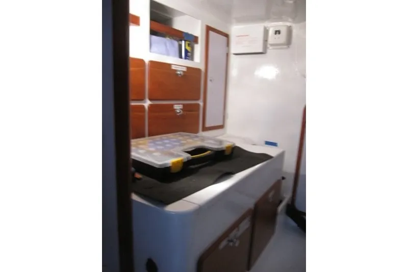 Slide: The Image of Interior of a 2014 Outbound 46 sailboat with wooden cabinets and storage compartments. - 21