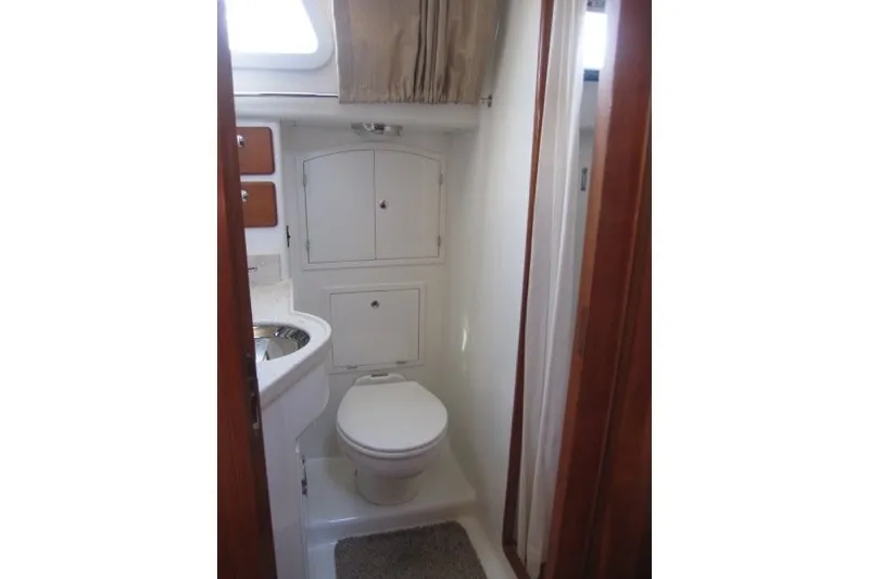Slide: The Image of Compact bathroom in 2014 Outbound 46 yacht with toilet, sink, and storage cabinets. - 17