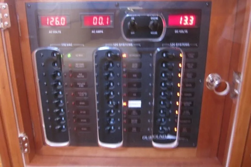 Slide: The Image of Electrical control panel on a 2014 Outbound 46 yacht, displaying voltage and amperage readings. - 25