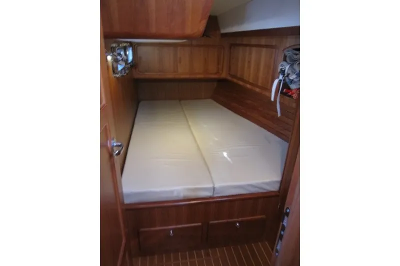 Slide: The Image of Cozy cabin interior of 2014 Outbound 46 yacht with wooden finish and bed. - 14