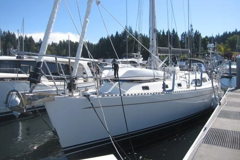 Slide: The Image of Sailboat docked at marina, Outbound 46 model, 2014, surrounded by forested landscape. - 50