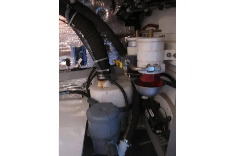 Slide: The Image of Engine compartment of a 2014 Outbound 46 yacht, featuring hoses and mechanical components. - 20