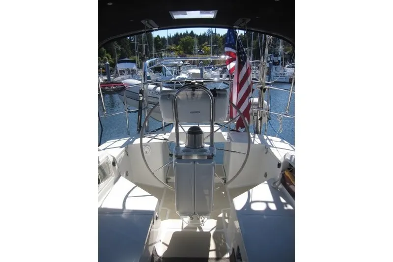 Slide: The Image of Cockpit view of 2014 Outbound 46 sailboat with American flag in marina setting. - 28
