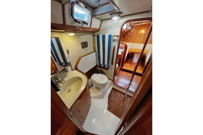 Slide: The Image of Bathroom interior of a 1994 Hylas 49 yacht, featuring sink, toilet, and wooden accents. - 13