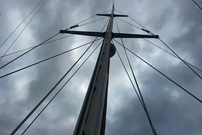 Slide: The Image of Mast of 1994 Hylas 49 sailboat against cloudy sky, showcasing rigging details. - 43