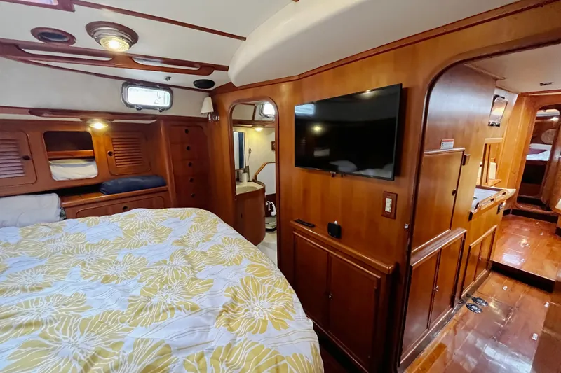 Slide: The Image of Interior of a 1994 Hylas 49 yacht with wood paneling and a cozy bedroom. - 12