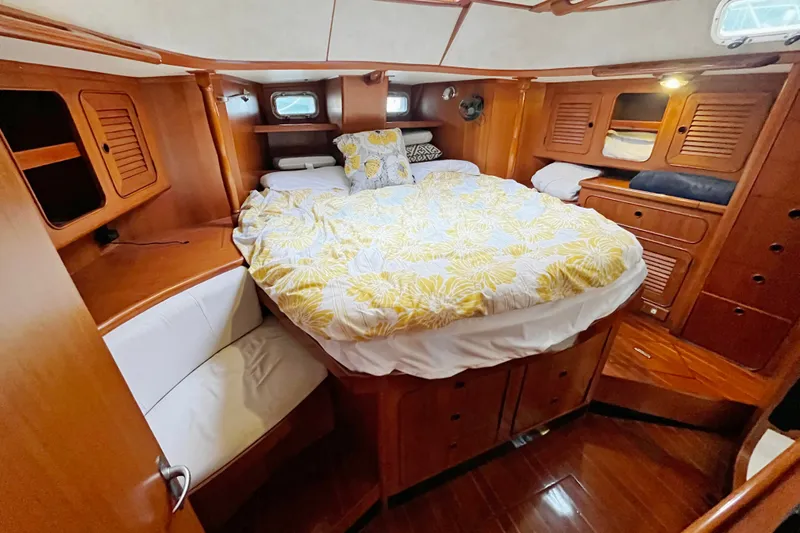 Slide: The Image of Cozy cabin interior of a 1994 Hylas 49 yacht with wooden furnishings and a comfortable bed. - 11