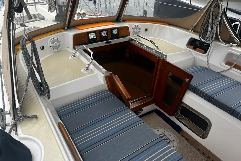 Slide: The Image of Interior view of a 1994 Hylas 49 sailboat cockpit with striped seating and wooden hatch. - 55
