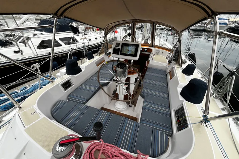 Slide: The Image of Cockpit of a 1994 Hylas 49 sailboat with striped seating and navigation equipment. - 48