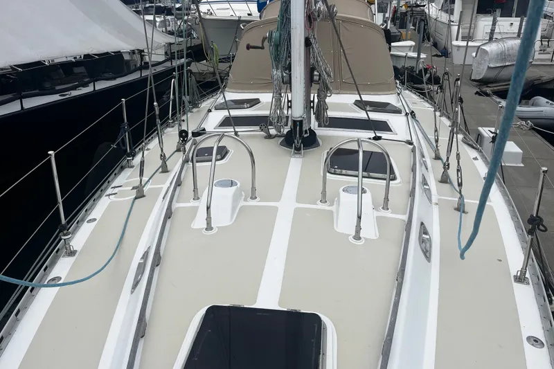 Slide: The Image of 1994 Hylas 49 sailboat deck with rigging and hatches at a marina. - 42