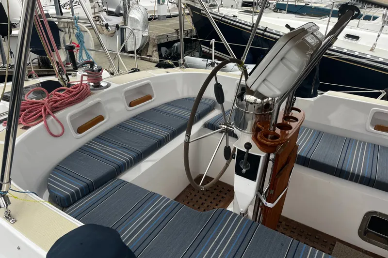 Slide: The Image of Cockpit of a 1994 Hylas 49 sailboat with striped seating and steering wheel. - 51