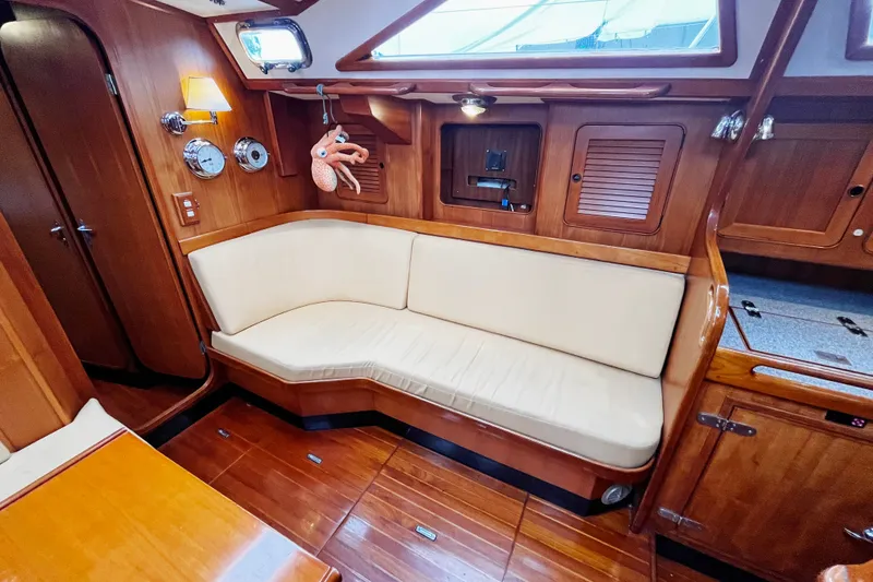 Slide: The Image of Interior of 1994 Hylas 49 yacht with wooden paneling and cream seating. - 7