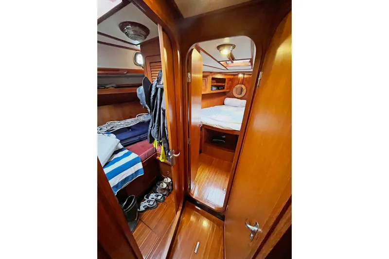 Slide: The Image of Interior of a 1994 Hylas 49 yacht, featuring cozy wooden cabins and bedding. - 17