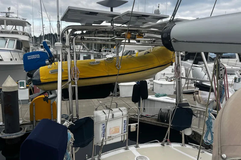 Slide: The Image of Sailboat docked with yellow dinghy and Honda Marine motor, Hylas 49, 1994 model. - 60
