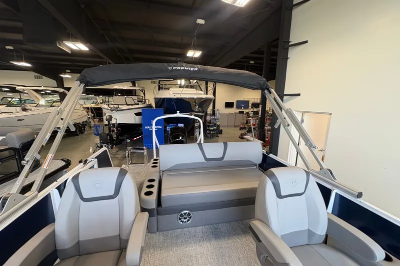Slide: The Image of 2027 Premier 220 Sunscape RL - DL boat interior with seating and canopy in showroom. - 15