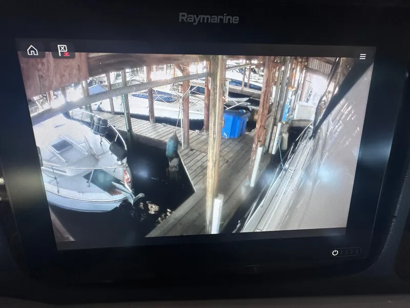 Slide: The Image of A boat is docked in a covered marina next to a wooden pier. - 18