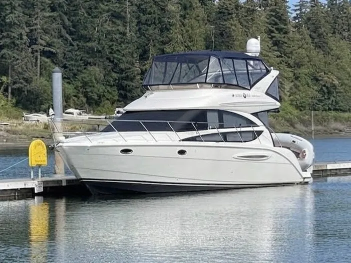 The Image of 2009 Meridian 391 Sedan docked, featuring two decks and an enclosed flybridge. - 0